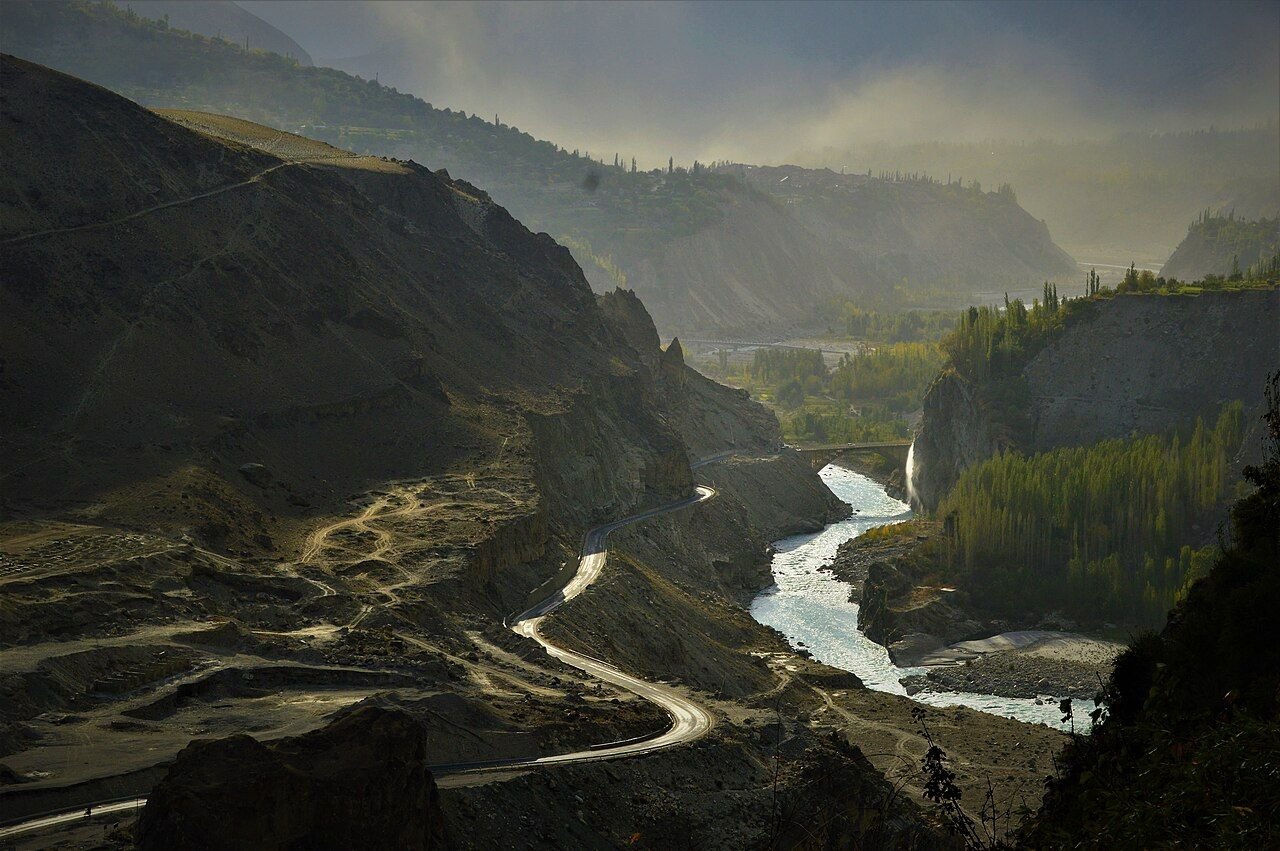 Karakoram Highway winding beside a river through mountain scenery in Gilgit-Baltistan, Pakistan
